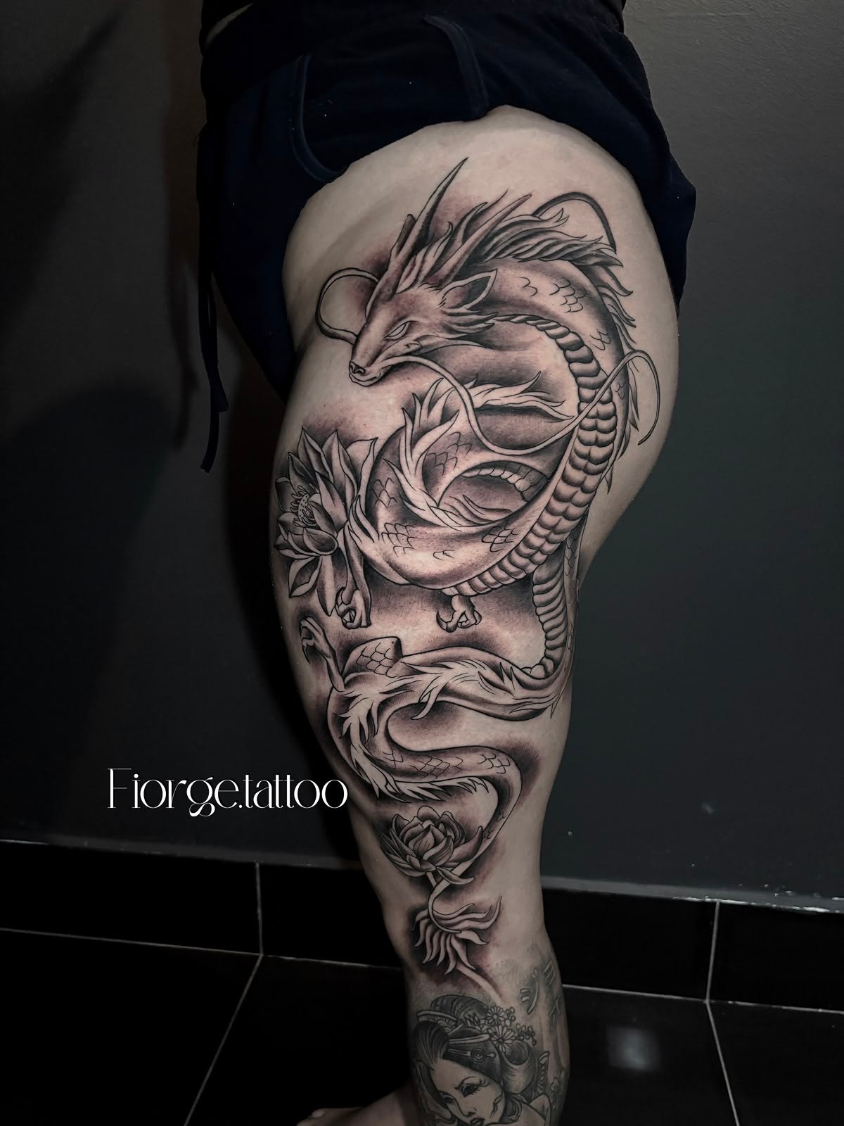 Tatuagem de dragão oriental em preto e cinza na coxa