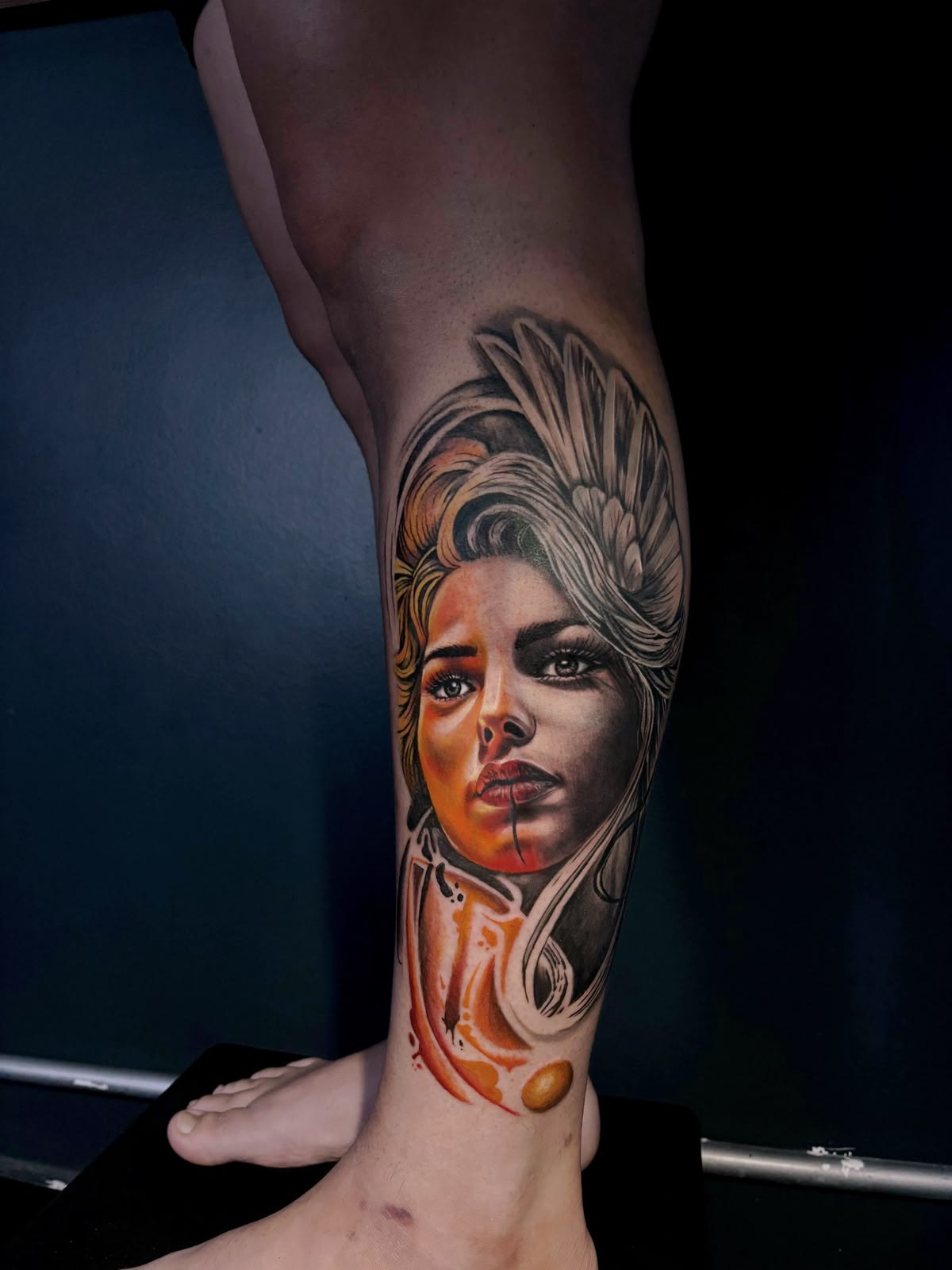 Tatuagem realista colorida de rosto feminino na perna